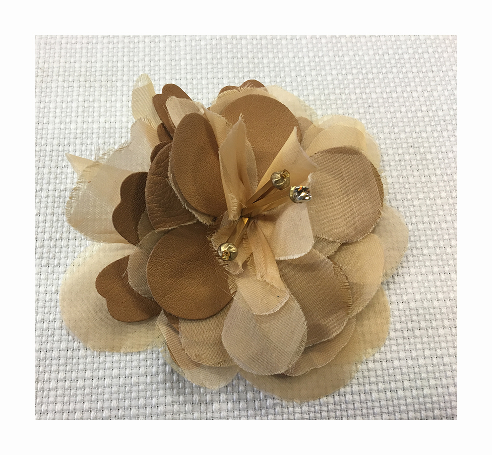 Vintage effect flower composed by different materials including also leather and organza