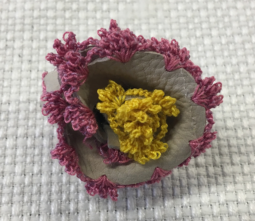 Flower made with two different materials : leather and thread