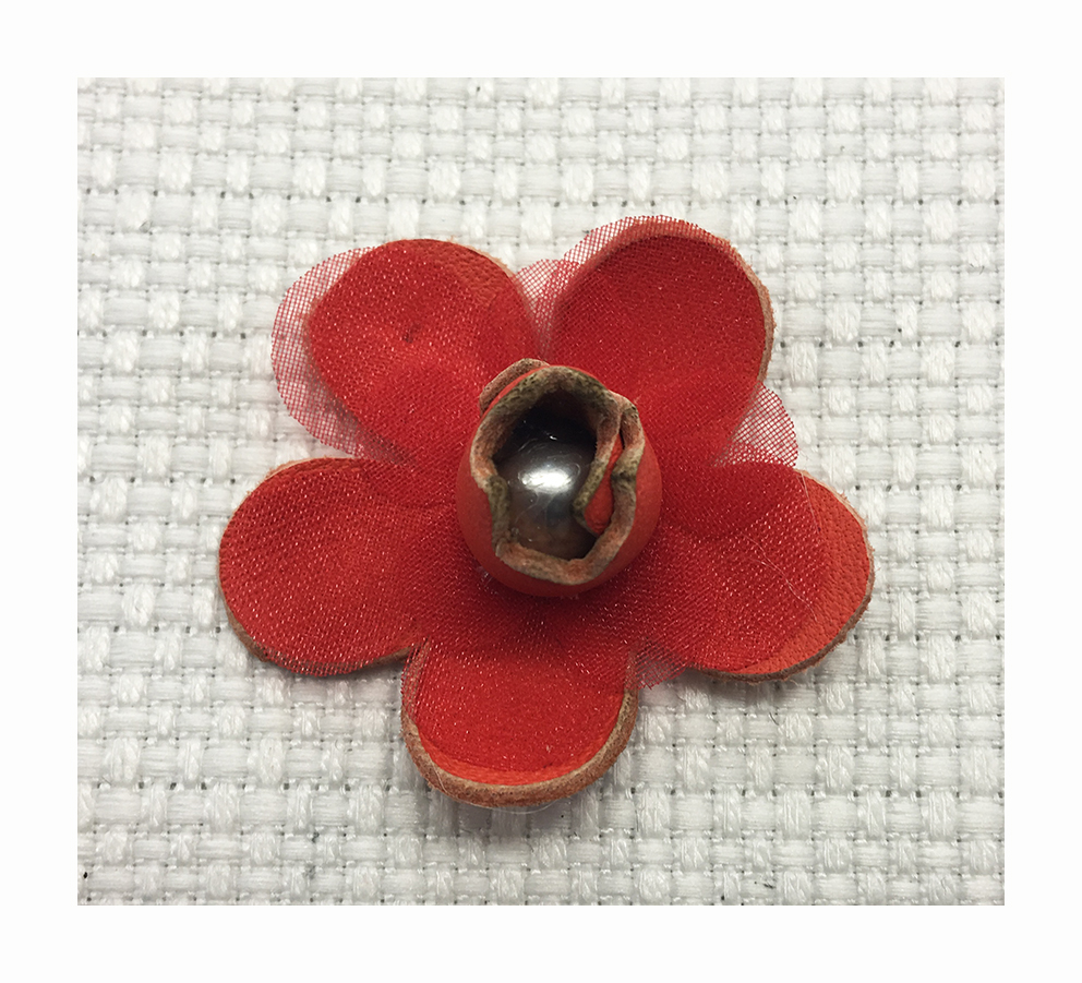 Thermoformed flower in cut leather combined with a tulle flower and a pearl